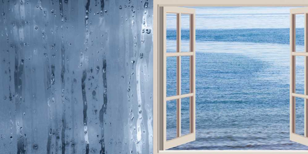 Eine Glas-Duschabtrennung mit Dampf, daneben ein offenes Fenster, das aufs Meer blickt