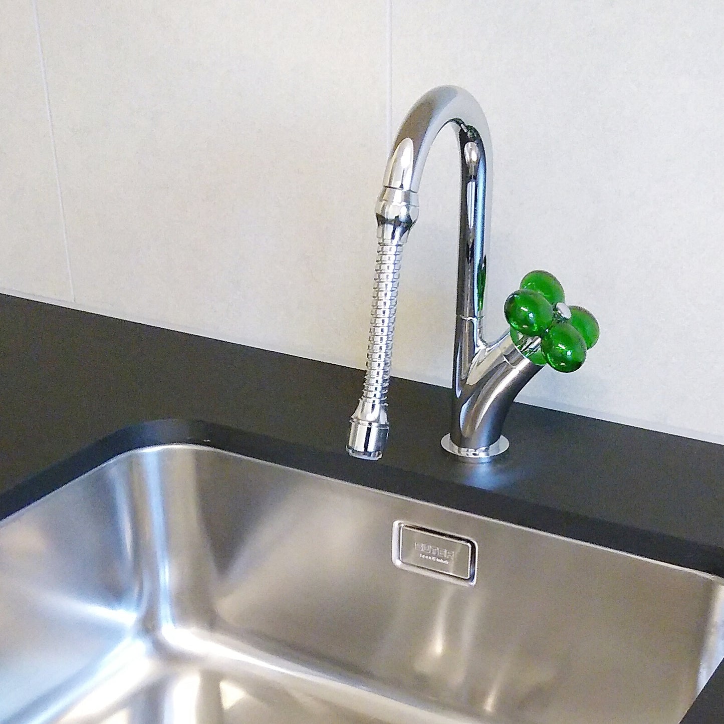 Ecofleur, robinetterie à démarrage à froid avec poignée verte sur un évier de cuisine en inox