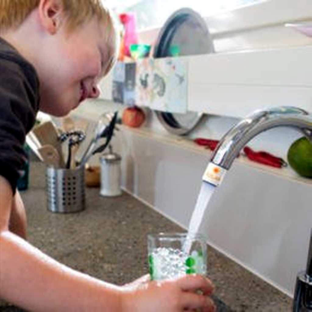 Association Sdes professionnels de l'énergie solaire: Swiss Solaruisse:   un enfant remplit un verre sous le robinet équippé d'un AquaClic économique